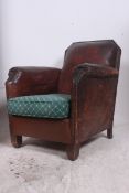 A 1930's Art Deco French full grain leather club armchair. The barrel arms with sloped back having