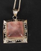 A silver 925 and amethyst ladies pendant and chain. The central cushion stone mounted on a pierced