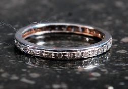 A ladies 18ct white gold full eternity diamond ring being stamped to inner hoop