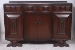 A 1930's Art Deco oak sideboard comprising a series of cupboards and drawers. Measures: 93cms x