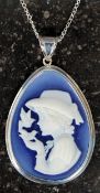 A silver cameo pendant necklace on a white metal chain