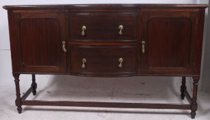 A 20th century mahogany sideboard, featuring a central bank of two drawers flanked by cupboards