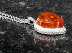A white metal and amber style heart shap