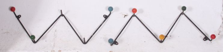 A pair of retro wall hanging Atomic coat