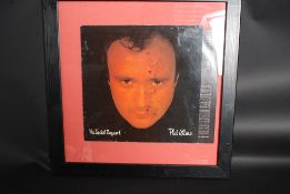 A framed Phil Collins signed record set