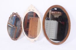 An Edwardian mahogany oval bevelled edge