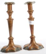 A pair of copper and brass candlesticks