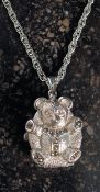 A white metal teddy bear watch on a chai