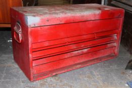 A vintage red metal industrial tool box.