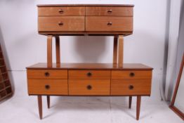A retro low teak sideboard raised on tap