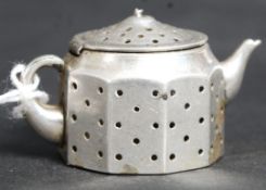 An American silver tea infuser in the fo