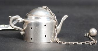 An American silver tea infuser in the fo