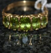 A 9ct gold peridot ring, decorated shoul