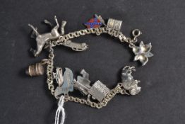 A silver charm bracelet having charms to include flowers, horse, buffalo and others.