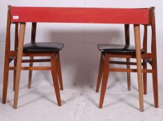Retro red formica kitchen table having detachable legs with a pair of black vinyl retro chairs.