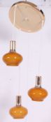 A retro 1970's ceiling light / chandelier having 3 hanging amber coloured glass shades