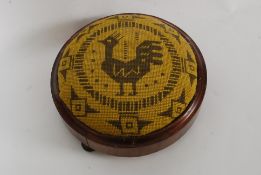 A Victorian mahogany tapestry upholstered / needlepoint circular footstool being raised on pad feet.