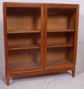 A 20th century Industrial Air Ministry golden solid oak bookcase raised on squared supports having