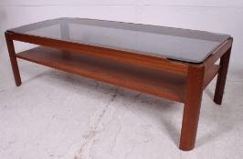 A retro 1970's teak and smoked glass coffee table raised on squared supports with chamfered from