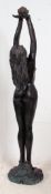 A large resin constructed garden fountain in the form of a nude women raised on a naturalistic