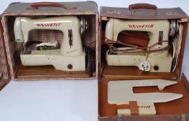 Two cased mid century electric portable Helvitia sewing machines, both with  accessories.