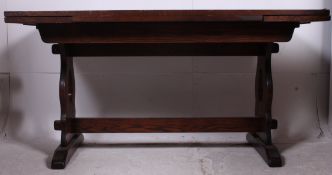 A 20th century large draw leaf refectory dining table raised on lyre shaped supports united by