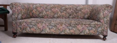 An Edwardian mahogany tapestry upholstered Chesterfield sofa settee being raised on bun feet with
