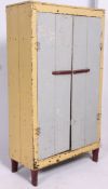 A good Shabby Chic early 20th century industrial painted pine upright cabinet having twin doors