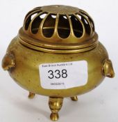 A Chinese bronze incense burner of round form having grid form top with shaped embellishments to