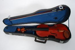 A cased Chinese made students Violin with bow within a case.