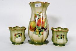 A three piece Staffordshire vase and garniture set bearing transfer printed fruit scenes.