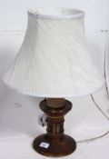 A 20th century wooden based table lamp with turned oak column base with a white shade to top.