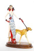 A Deco style figurine of a girl with a Cheetah on leash being signed to base mounted on wooden