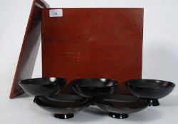 A cased wooden set of Chinese laquered wooden rice bowls stylised with cray fish having original