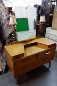 A 1970's G-Plan Ernest Gomme oak dressing chest of drawers / table raised on tapered legs with