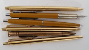 A collection of gold plated writing pens.