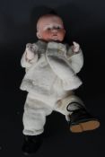 An unusual 19th century bisque head small child boy doll having blue eyes,