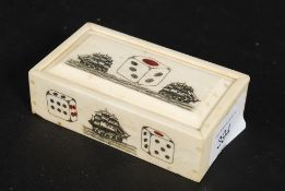 A bone scrimshaw style dice box of rectangular form stylised with dice and tall ships