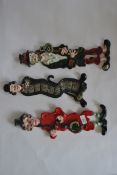 A collection of ceramic wall plaque figurines of a band and a vagabond along with Charlie Chaplin