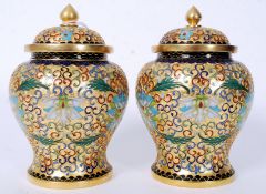 A pair of 20th century gilt and enamel painted urns complete with the lids having finial crowns.