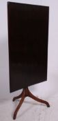 A Victorian and later tilt top side table being raised on a tripod base with later tilt top of