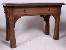 A 20th century Arts & Crafts solid oak console table being raised on squared supports with single
