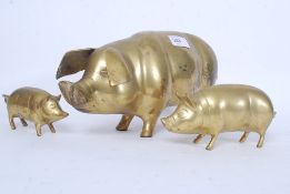 A large brass 20th century pig figurine together with 2 matching similar ones