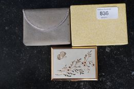 A vintage mid 20th century musical ladies yellow metal compact complete in the original packing by