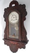 A heavily carved oak cased wall hanging Ansonia 8 day wall clock,