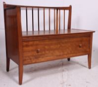 A 1970's teak wood telephone table raised on shaped supports having a crop centre top with gallery