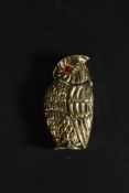 A 20th century brass worked vesta case in the form of an owl having glass set eyes