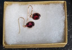 A pair of 9ct gold oval drop earrings inset with garnet stones, weight 1.