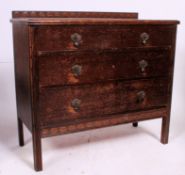 A 1930's Art Deco oak chest of drawers being raised on squared legs having a series of drawers with