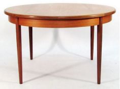 A 1970's G-Plan teak wood Chester range circular dining table raised on tapered,